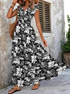 Detail view of a black and white leaf print maxi dress with a V-neckline and short sleeves.