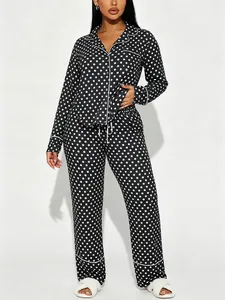 Full view of women's black polka dot pajama set with white piping and lapel collar