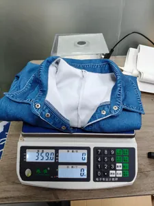 Balance numérique affichant le poids d'une robe en denim à col en V soit 359 grammes