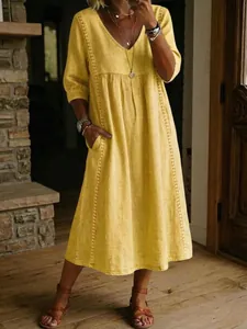 Elegante abito midi giallo da donna con scollo a V, dettagli ricamati e tasche laterali