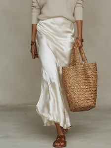 Élégante jupe midi en satin blanc avec un pull en maille beige dans un style haute couture