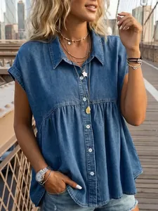 Lifestyle detail of a blue denim button-down peplum top worn on an urban bridge backdrop