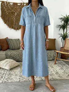 Vue complète d'une robe longue ample en imitation denim avec col en V et poches avant.