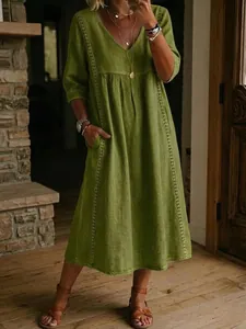 Abito verde casual con scollo a V, mezze maniche e ricami verticali in ambiente lifestyle