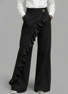 Detailed shot of black high-waisted denim trousers with asymmetrical ruffle