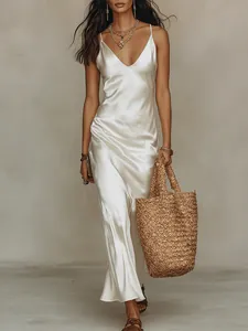 Détail d'une robe nuisette élégante en satin blanc sur mannequin avec sac en paille