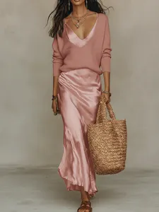 Élégant pull en maille rose associé à une jupe midi en satin assortie pour un look chic