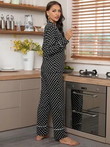 Woman in black polka dot pajama set standing in a cozy kitchen setting