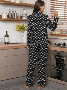 Elegant back view of women's black and white polka dot pajama set in a cozy kitchen