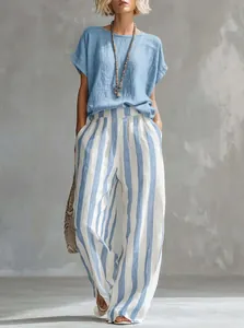 Detalle de conjunto para mujer con blusa azul y pantalón ancho de rayas verticales