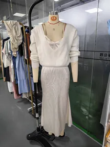 Détail d'un ensemble pull en maille blanc et robe en satin sur un mannequin