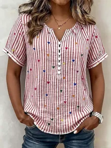 Detail of a red and white striped V-neck blouse with colorful heart patterns and buttons.