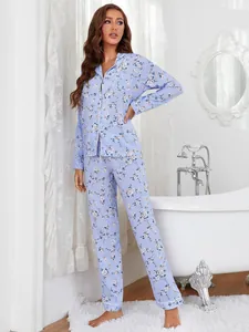 Women's blue floral long-sleeved pajama set in a stylish white bathroom setting.