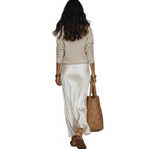 Ensemble 2 pièces femme élégant avec haut en maille beige et robe en satin blanc.