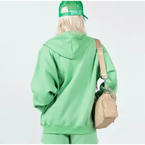 Back view of women's oversized green hoodie and matching shorts set streetwear look.