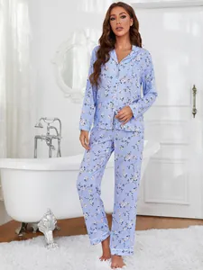 Two-piece blue floral pajama set shown in a cozy white bathroom lifestyle setting