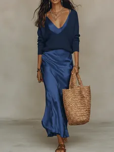 Détail d'un ensemble élégant pull en maille et robe midi en satin bleu