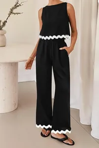 Detail of black 2-piece set featuring a sleeveless crop top and pants with white wavy trim.