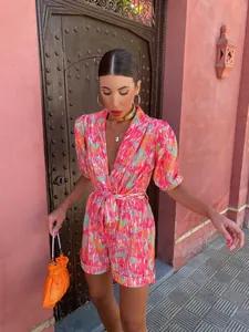 Vibrant abstract print short sleeve romper with deep V-neck and stylish tie waist belt