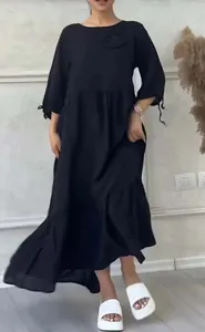 A woman in a stylish black long-sleeved dress with crew neck and tiered hem detail
