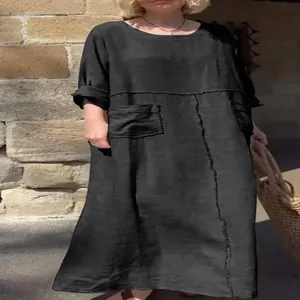 Detail view of a loose-fit black cotton linen maxi dress with front pockets and raw seams.