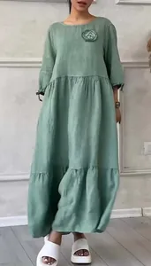 Detailed view of sage green casual linen dress featuring a stylish pleated flower accent