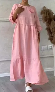 Detail view of pink long sleeve casual dress with shirred tiers and floral accent