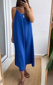 A full-length view of a bright blue loose-fitting sleeveless spaghetti strap maxi dress