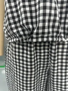Λεπτομέρεια από ασπρόμαυρο ύφασμα gingham και ελαστική μέση σε γυναικείο σετ ολόσωμης φόρμας