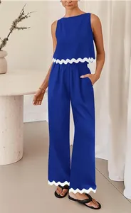 Detailed view of women's blue two-piece set featuring stylish white scalloped wavy trim.
