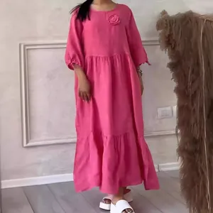 Elegant rose pink round neck tiered casual maxi dress featuring long sleeves and floral accent