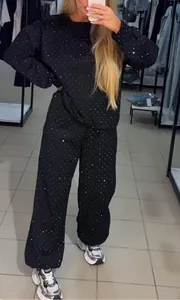 Selfie miroir présentant un ensemble de détente noir orné de strass avec jogging assorti