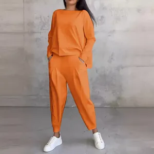 Ensemble deux pièces pour femme avec haut à manches longues orange et pantalon à poches.