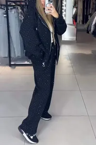 Mirror selfie of a black rhinestone hooded zip-up tracksuit set worn by a model