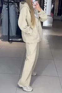 Detailed view of women's beige hooded tracksuit with sparkling rhinestone embellishments.