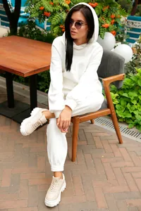 Vue lifestyle d'une femme en ensemble sweat à capuche blanc uni et pantalon de jogging.