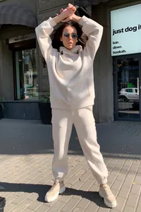 Vue de rue d'un ensemble de survêtement beige uni à capuche deux pièces décontracté.