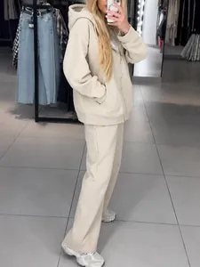 Oversized beige tracksuit set with hoodie and rhinestone embellished wide-leg pants.