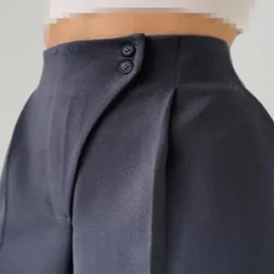 Detailansicht des eleganten Doppelknopf-Verschlusses an einer marineblauen Maßhose