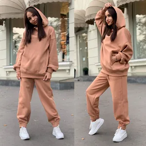 Deux angles d'un ensemble de survêtement caramel pour femme avec sweat à capuche