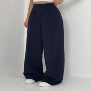 Detailansicht der Hose mit hoher Taille und elegantem asymmetrischem Knopfdetail.