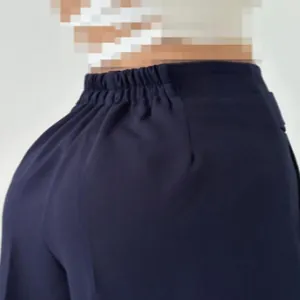Detailansicht des elastischen Hosenbundes und der Stoffstruktur der dunkelblauen Stoffhose