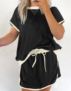 Conjunto informal de dos piezas para mujer con camiseta negra de hombros caídos y pantalones.