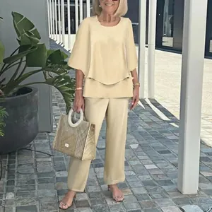 Full-body view of a stylish beige two-piece set featuring a layered top and pants.