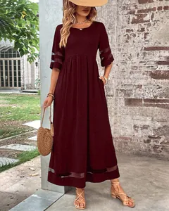 Elegante vestido largo color vino con mangas de malla y prácticos bolsillos laterales.