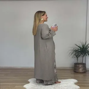 Seitenansicht eines taupefarbenen Leinen-Sets mit asymmetrischem Oberteil und Blumenhose