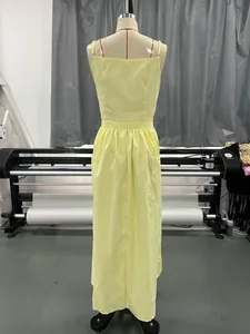 Back view of a sleeveless yellow maxi sundress displayed on a mannequin in a studio.