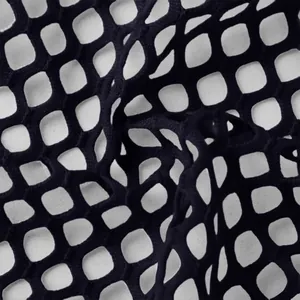 Close-up macro detail of black hollow-out fishnet mesh fabric for trendy women's apparel