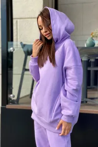 Détail d'un ensemble sweat à capuche et jogging lilas oversize dans un cadre de vie.