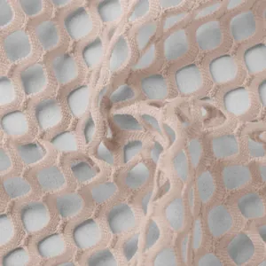Close-up detail of soft beige hollow mesh fabric texture for elegant women's dress